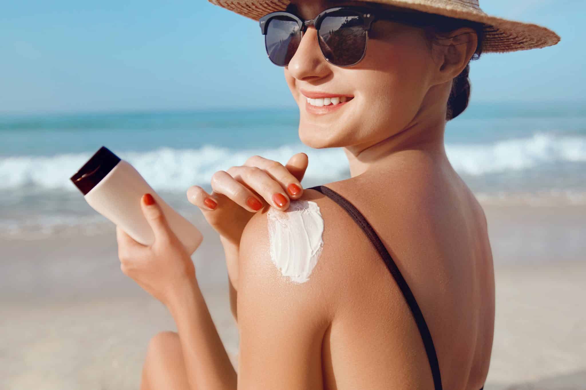 Woman Applying Sunscreen On Shoulder For Sun Protection