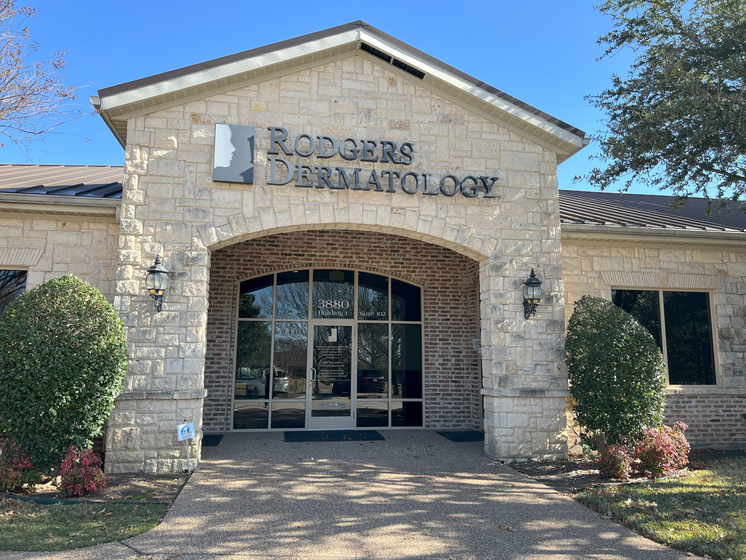 The white brick arch and inset, red brick facade of Rodgers Dermatology in Frisco, TX